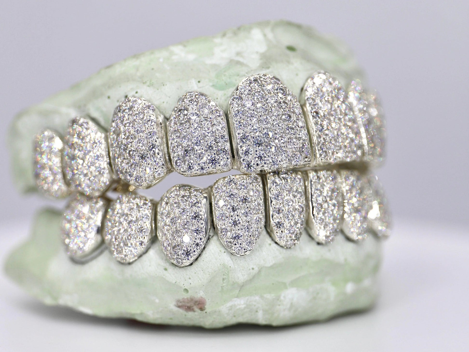 Silver rimless dental grill with gemstones on a white background